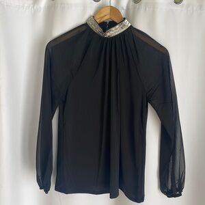 Beautiful blouse with embellished collar and see-through sleeves.